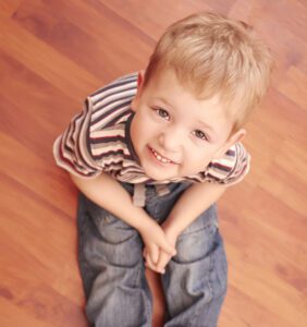 Toddler sitting on beautiful hardwood durable and resistant flooring